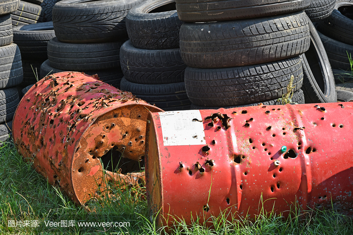 垃圾填埋场的旧轮胎和生锈的金属桶